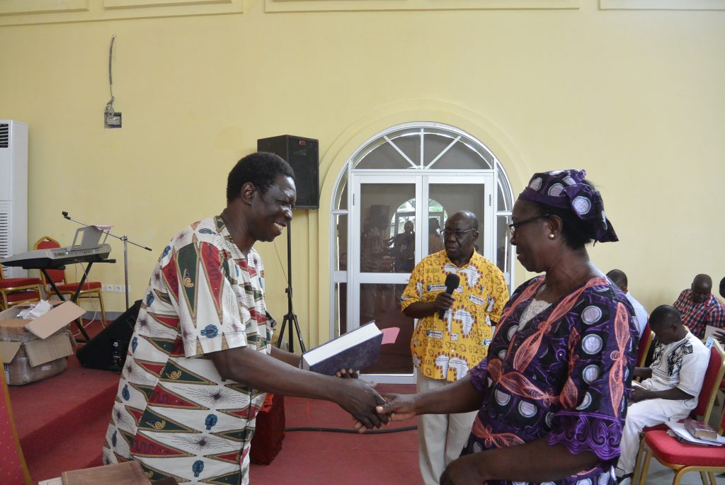 Woman receives graduation certificate and bible
